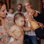 Intimate moment capturing a baby's baptism in a church with family present.