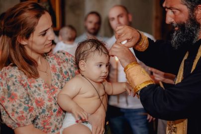 Intimate moment capturing a baby's baptism in a church with family present.