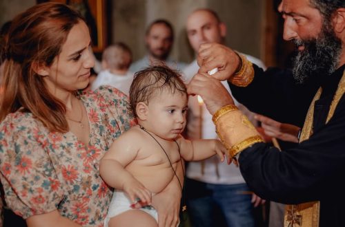 Intimate moment capturing a baby's baptism in a church with family present.