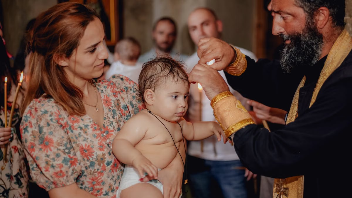 Intimate moment capturing a baby's baptism in a church with family present.