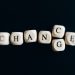 Letter dice forming the word 'Change' on a dark background, symbolizing transformation and opportunity.